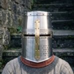 Riveted steel great helm with brass cross reinforce, knotwork engraved band and drilled breaths worn over a chainmail collar and brown gorget