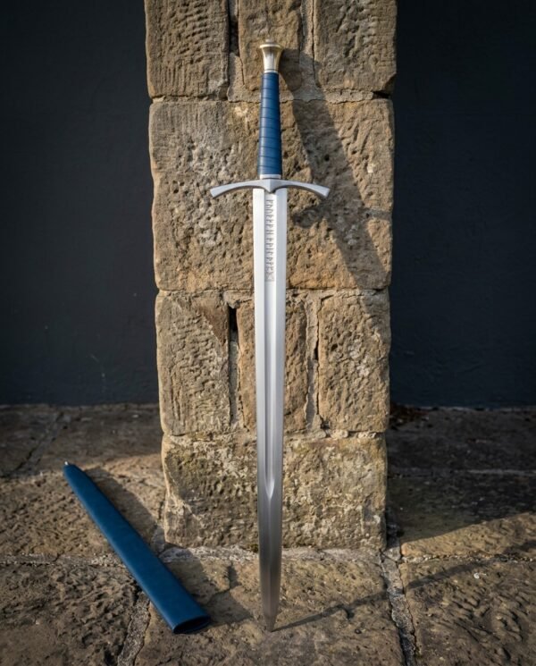 Runic knightly sword standing against a sandstone pillar with a blue dyed leather grip, cut rune column and faceted pommel above its blue scabbard