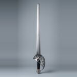 Schiavona basket hilt sword with a full bar steel basket, lobed cap pommel and black ribbed grip with brass ferrules standing point up against a plain grey studio backdrop