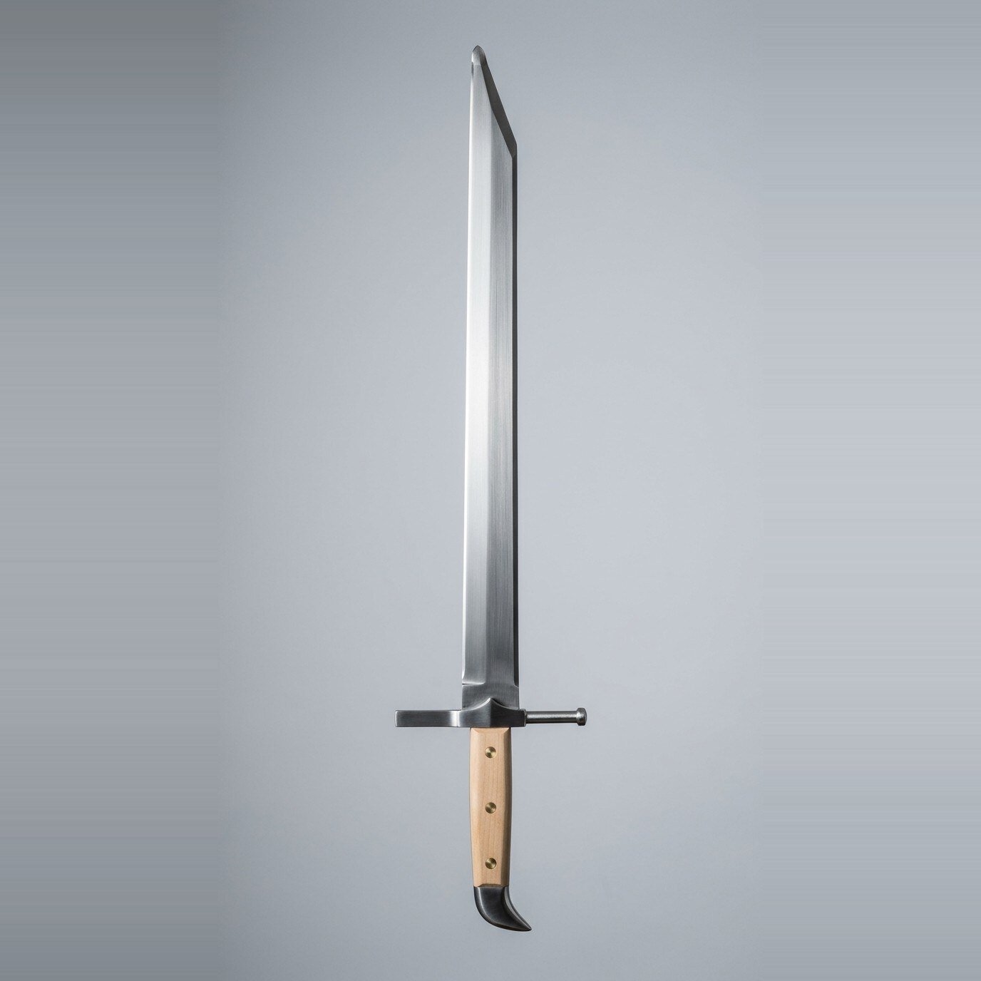 Torvhaug sharp langes messer Sharp langes messer with a ground single edge, clipped point, wooden scale grip held by three brass rivets and a blackened beak shaped butt cap against a plain grey studio backdrop
