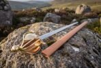 Short hunting hanger with its tan leather scabbard and polished brass fittings