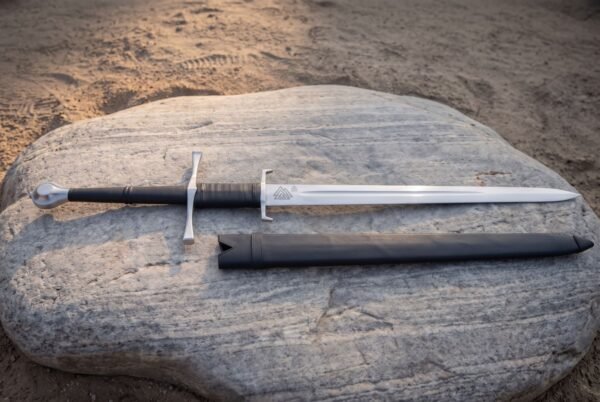 Thirty two inch fullered blade in mirror polished steel, twin guards hooked at the terminals