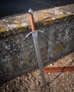 Three copper rivets inset low on the flat of a folded Damascus blade