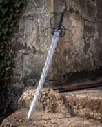 Waves running the full length of a folded Damascus flame blade above a blackened hilt