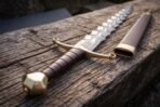 Wavy Damascus blade with its brown leather scabbard, brass locket and chape matching the hilt