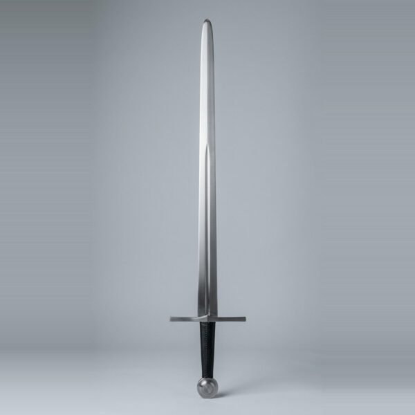 Wide fuller arming sword trainer with a plain straight cross, a fuller running two thirds of the blade, black leather seam grip and bossed wheel pommel laid on a plain grey studio backdrop