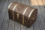 Wooden Viking chest with domed lid seen from above showing the Helm of Awe carving and riveted brass straps