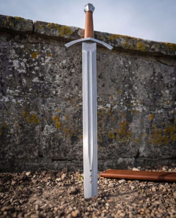 Yggdrasil roundel cut into the ricasso of a broad Damascus blade with a deep fuller
