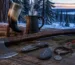 Bearded axe, drinking horn, Damascus folding knife and rune stone laid out on an oak table in winter